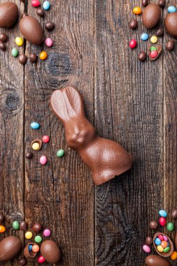 Çikolata Paskalya tavşanı ve ahşap arka plan üzerinde yumurta