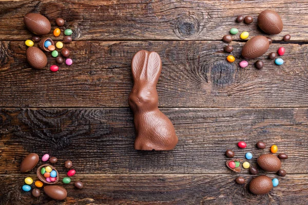 Chocolate Easter bunny and eggs on wooden background — Stock Photo, Image