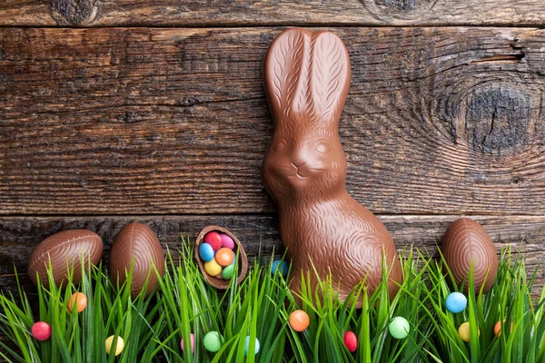 Chocolate Easter bunny and eggs on wooden background — Stock Photo, Image