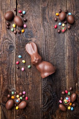 Çikolata Paskalya bunny, yumurta ve tatlılar rustik arka plan üzerinde