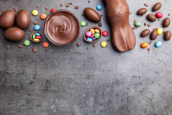 Lapin de Pâques chocolat, oeufs et bonbons sur fond rustique — Photo