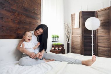 İyi vakit geçiriyor yatakta onun sevimli çocukla mutlu anne