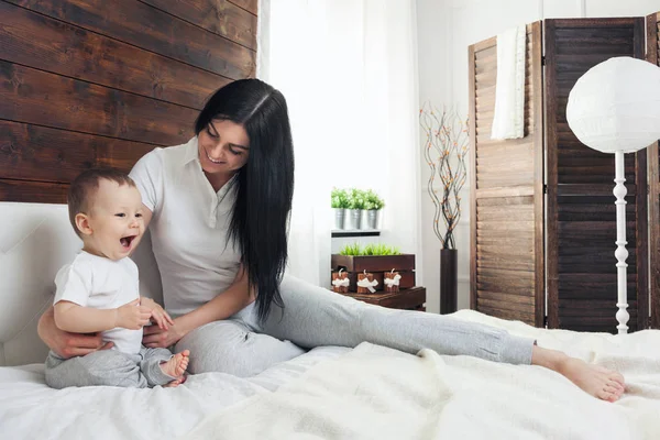 Mère heureuse avec son mignon enfant sur le lit passer un bon moment — Photo