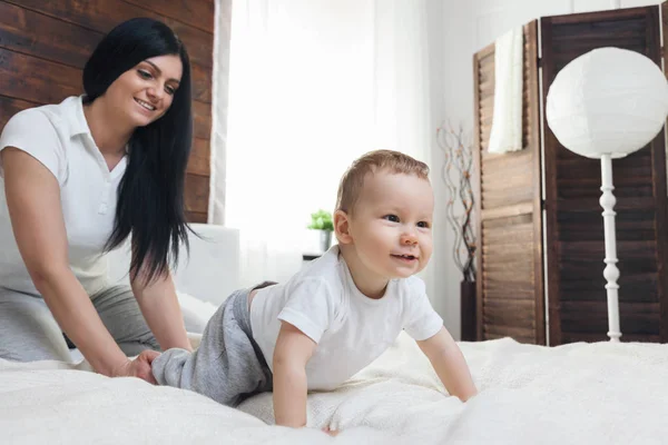 Happy mother with her cute child on the bed having a good time — Stock Photo, Image