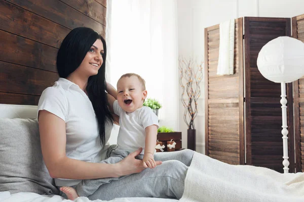 Happy mother with her cute child on the bed having a good time — Stock Photo, Image