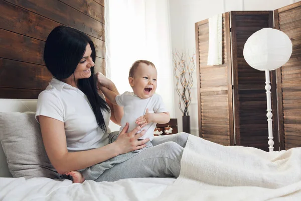 Mère heureuse avec son mignon enfant sur le lit passer un bon moment — Photo