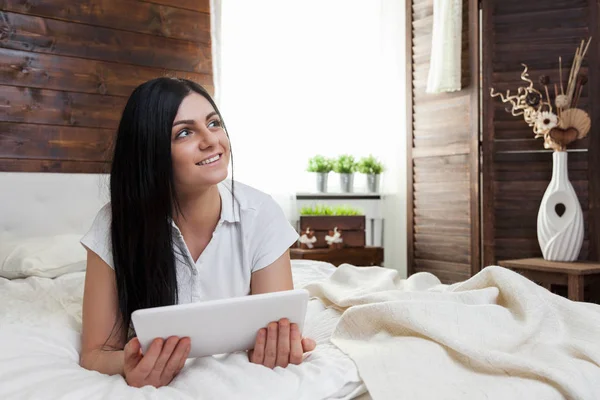 Krásná žena, relaxace na lůžku a používání tabletu — Stock fotografie