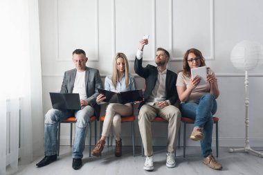 Grup bekleme odasında sandalyelere oturan yaratıcı insan