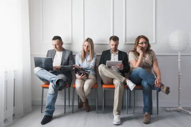 Grup bekleme odasında sandalyelere oturan yaratıcı insan