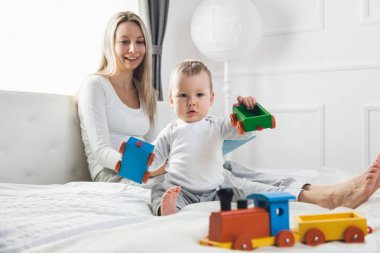 İyi vakit geçiriyor yatakta onun sevimli çocukla mutlu anne