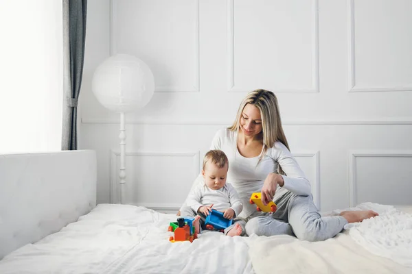 Mère heureuse avec son mignon enfant sur le lit passer un bon moment — Photo