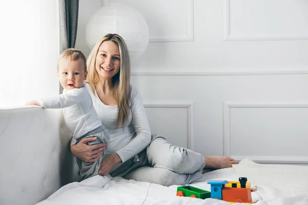 Mère heureuse avec son mignon enfant sur le lit passer un bon moment — Photo