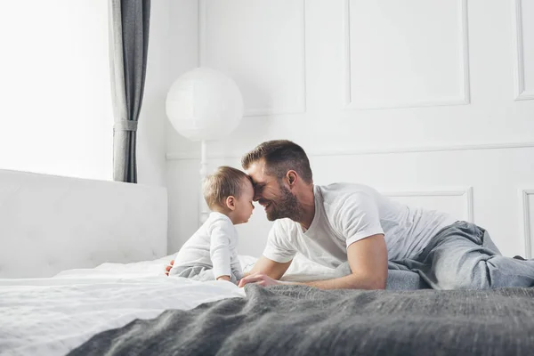 Happy father with his son playing at home on the bed — Stock Photo, Image