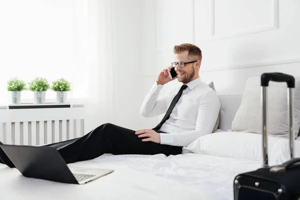 Empresario trabajando desde una habitación de hotel con su teléfono móvil — Foto de Stock