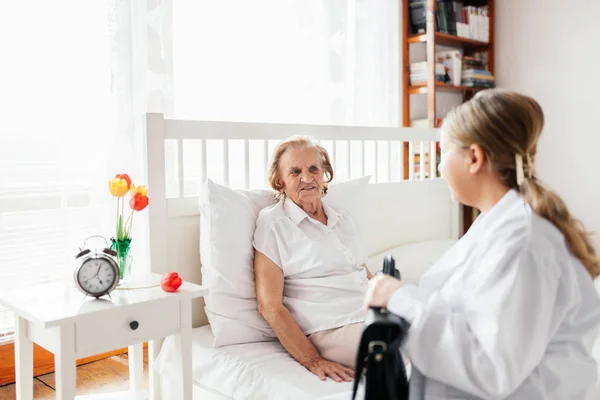 Fournir des soins aux personnes âgées. Médecin visitant un patient âgé à domicile . — Photo