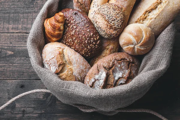 Ahşap arka plan bir torba içinde lezzetli taze ekmek
