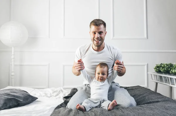 Tată fericit cu fiul său jucându-se acasă pe pat — Fotografie, imagine de stoc
