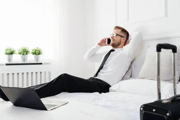 Geschäftsmann arbeitet vom Hotelzimmer aus mit seinem Handy — Stockfoto