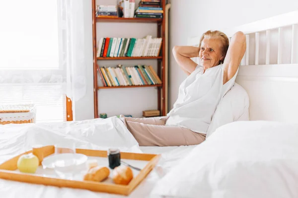 Yaşlı kadın yatakta kahvaltı — Stok fotoğraf