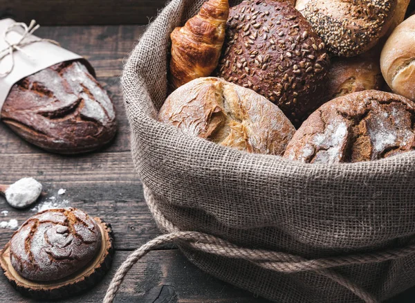Ahşap arka plan bir torba içinde lezzetli taze ekmek