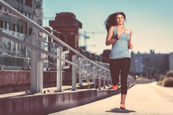 City workout. Beautiful woman running in an urban setting — Stock Photo, Image