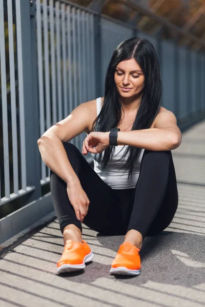 City workout. Beautiful woman with a smartwatch training in an urban setting — Stock Photo, Image