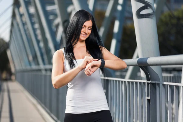 City workout. Beautiful woman with a smartwatch training in an urban setting — Stock Photo, Image