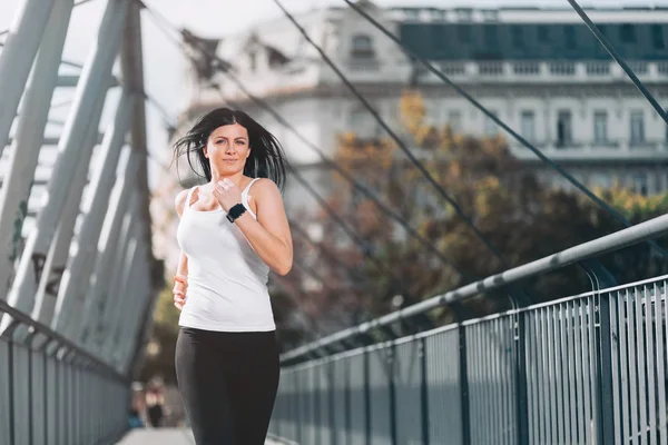 Entrenamiento en la ciudad. Hermosa mujer corriendo en un entorno urbano —  Fotos de Stock