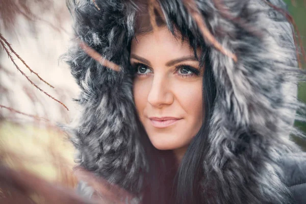 Vacker kvinna som bär en päls huva vinter — Stockfoto