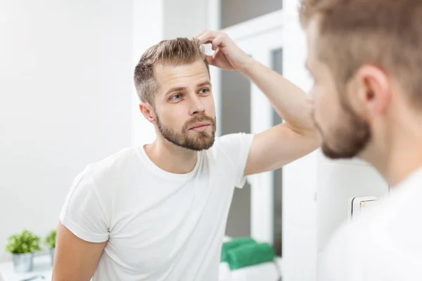 Bello giovane uomo preoccupato per la perdita di capelli — Foto Stock