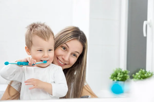 Lycklig mamma lära sin son att bush tänder — Stockfoto