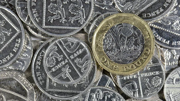 British Currency - One Pound Coin on a selection of five pence pieces