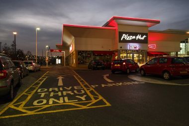 Swansea, İngiltere: 27 Aralık 2016: insanlar yürümek bir gece saat sürücü geçmiş. Pizza Hut bir Amerikan restoran ve pizza ve makarna gibi onun İtalyan-Amerikan mutfağı menü için bilinen franchise olduğunu. 