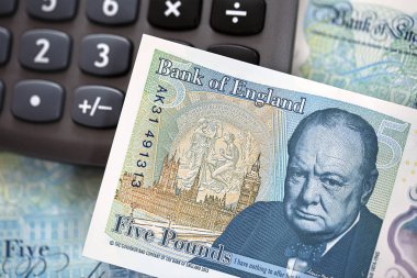 Londra, İngiltere: 07 Kasım 2016: yeni 2016 polimer beş Lirası Not sahtecilik caydırmak için tasarlanmış. Efendim Winston Churchill ters taraftaki resimde. Not Hesap makinesinde dinleniyor