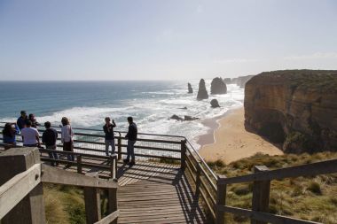 Melbourne, Australia: October 8, 2015: Tourist enjoy the Twelve Apostle Sea Rocks from the viewing boardwalk provided and maintained by the Port Campbell National Park. clipart