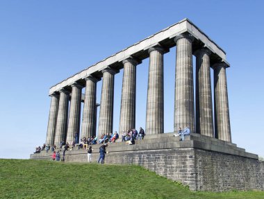 Edinburgh, İngiltere: 28 Mayıs 2016: turist oturup Calton Hill Edinburgh İskoçya Ulusal Anıt görünümünden tadını çıkarın. Asker ve Napolyon Savaşları sırasında ölen denizci anmak için inşa.