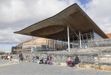 Cardiff, Uk: 10 Mart 2016: Döviz öğrenciler Welsh Ulusal Meclis Binası Cardiff Bay Area adımları oturmak. Derleme Galler hükümeti yasası 1998 tarafından oluşturulmuş.
