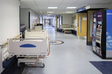 Swansea, İngiltere: 25 Kasım 2017: Hastanede boş bir koridor. Koridor yedek hastane sedyeleri ve temiz içme suyu satan bir otomat ile temiz. 