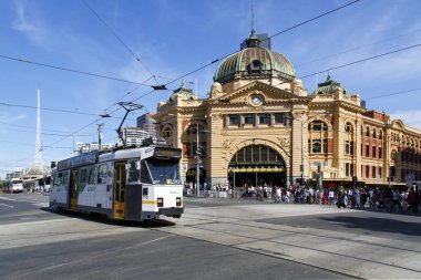 Melbourne, Avustralya: 07 Nisan 2018: Federasyon Meydanı'ndaki ikonik Flinders Street Station binasından bir tramvay geçiyor.