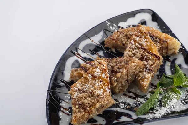 siyah plaka üzerinde Close-Up lezzetli ev yapımı kekler ile pudra şekeri fındık ve yeşil nane yaprakları 