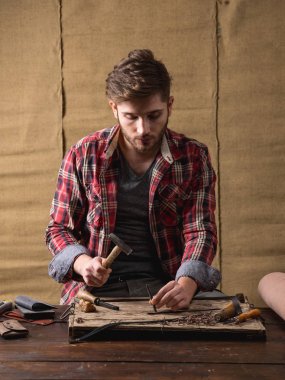 ahşap masa üzerinde deri ile kırmızı gömlekli sakallı yakışıklı