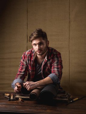 ahşap masa üzerinde deri ile kırmızı gömlekli sakallı yakışıklı