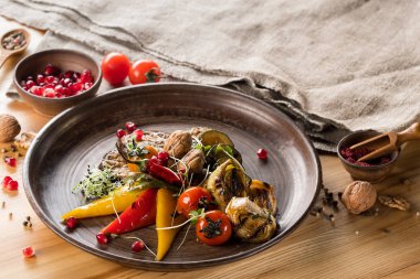 plaka üzerinde ızgara sebze ve nar taneleri ile kase, yakın çekim