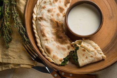 plaka ile ev yapımı pasta, kase ve mutfak eşyaları, otlar asitlendirilmiş krem kopya alanı ile Üstten Görünüm