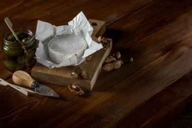 brie peyniri, fındık ve zeytin ve capperi kopya alanı rustik ahşap tablo ile kavanozlar ile düz lay