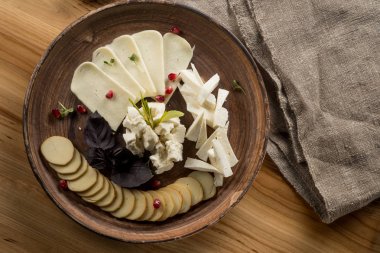 Otlar ve ahşap masa, üstten görünüm üzerinde nar taneleri ile çeşitli Peynir tabağı
