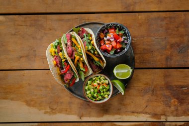 limon dilimleri ve kase ahşap masal kesilmiş sebzeler ile baharatlı tacos