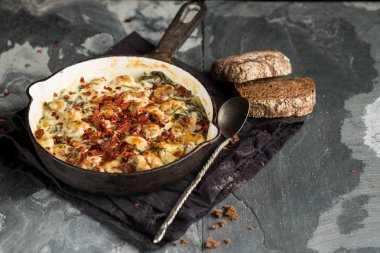 Üstten Görünüm içinde balık pastası peynirli tava ve siyah peçeteye kaşıkla ekmek