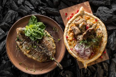 Balık ve otlar ve et ve kömür pişirme baharatlar ile ev yapımı ekmek ile plaka