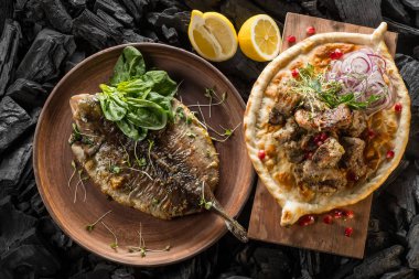 Balık ve otlar ve et ve kömür pişirme baharatlar ile ev yapımı ekmek ile plaka